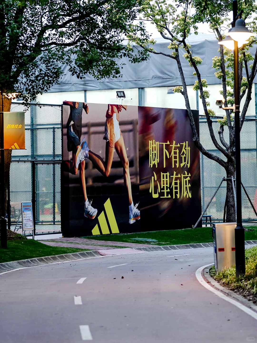 상하이 세기 공원(Century Park)에 설치된 아디다스의 대형 광고판. 공원 모퉁이에 광고판이 있다. 