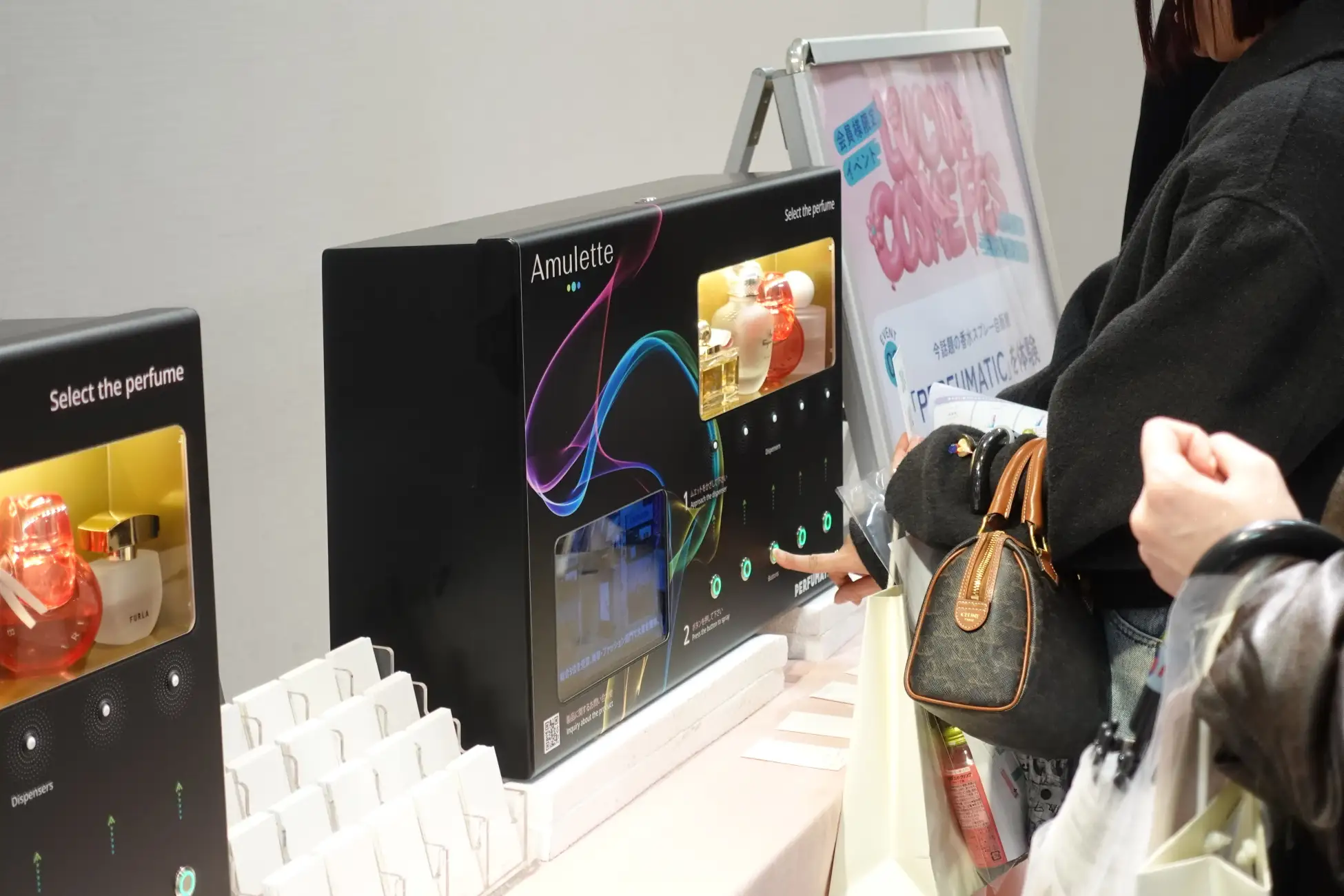 아뮬레트(Amulette)가 전개하는 스프레이형 향수 자판기 '퍼퓨매틱'. 고객이 향수 5종 중 하나를 시향하기 위해 버튼을 누르고 있다.