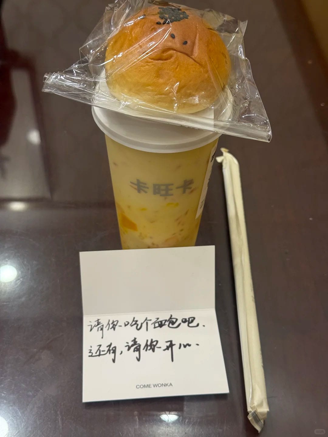 중국 밀크티 브랜드 카왕카(come wonka)에서 직원이 손님에게 손글씨로 쓴 카드와 빵, 음료를 준 모습