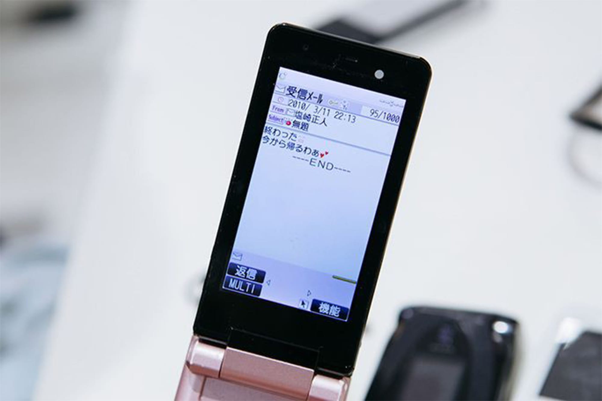 KDDI가 진행하는 ‘추억의 휴대폰 다시 켜기(おもいでケータイ再起動)’이벤트 사진. 고객이 복구된 피처폰 속 예전 메일을 보고 있다.